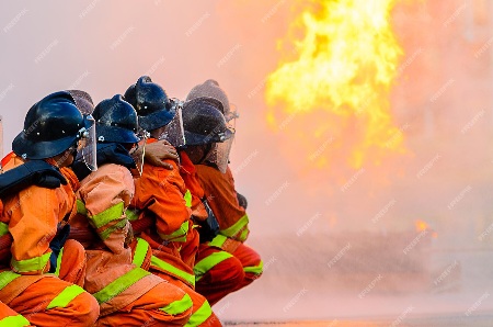 Firefighter with suits on practicing their technique with a hose.
